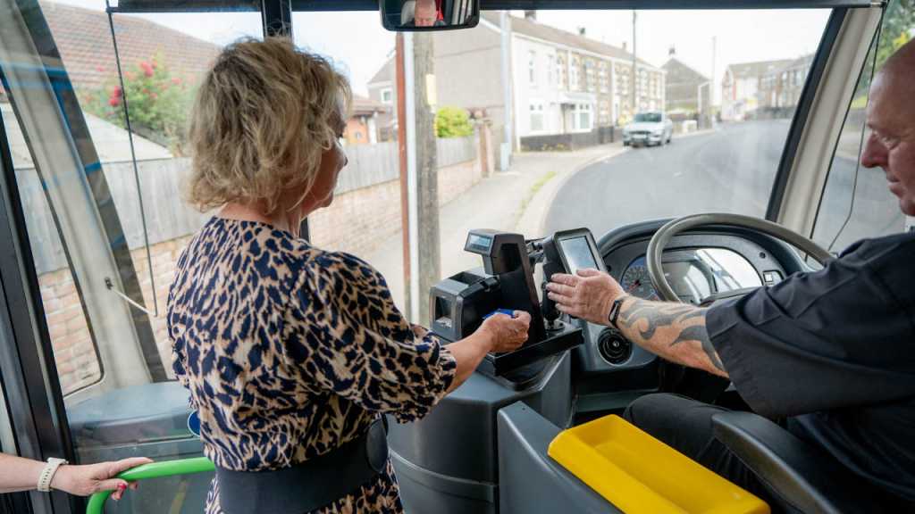A person buying a ticket on the bus